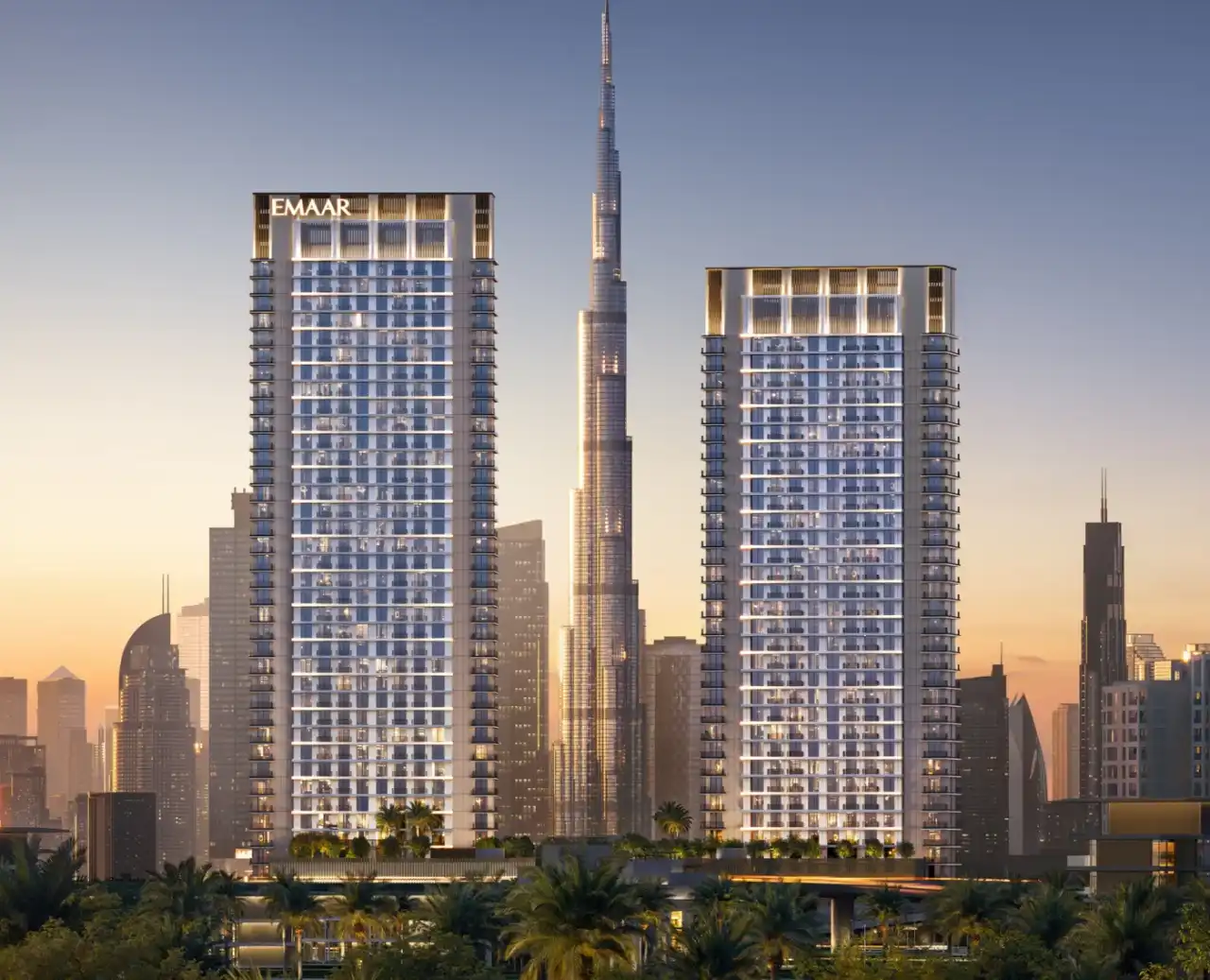 Two Emaar residential towers at sunset with the Burj Khalifa behind them