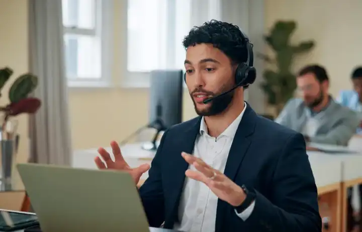 A support advisor on a headset talking to a client from a laptop