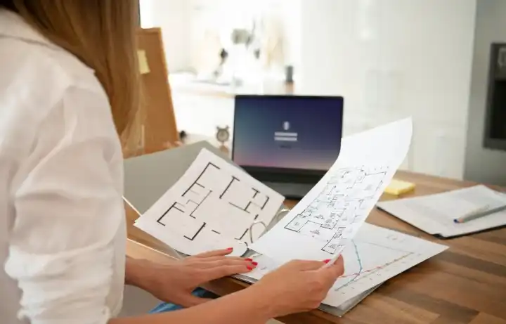 Floor plans and printed reports being reviewed together at a desk